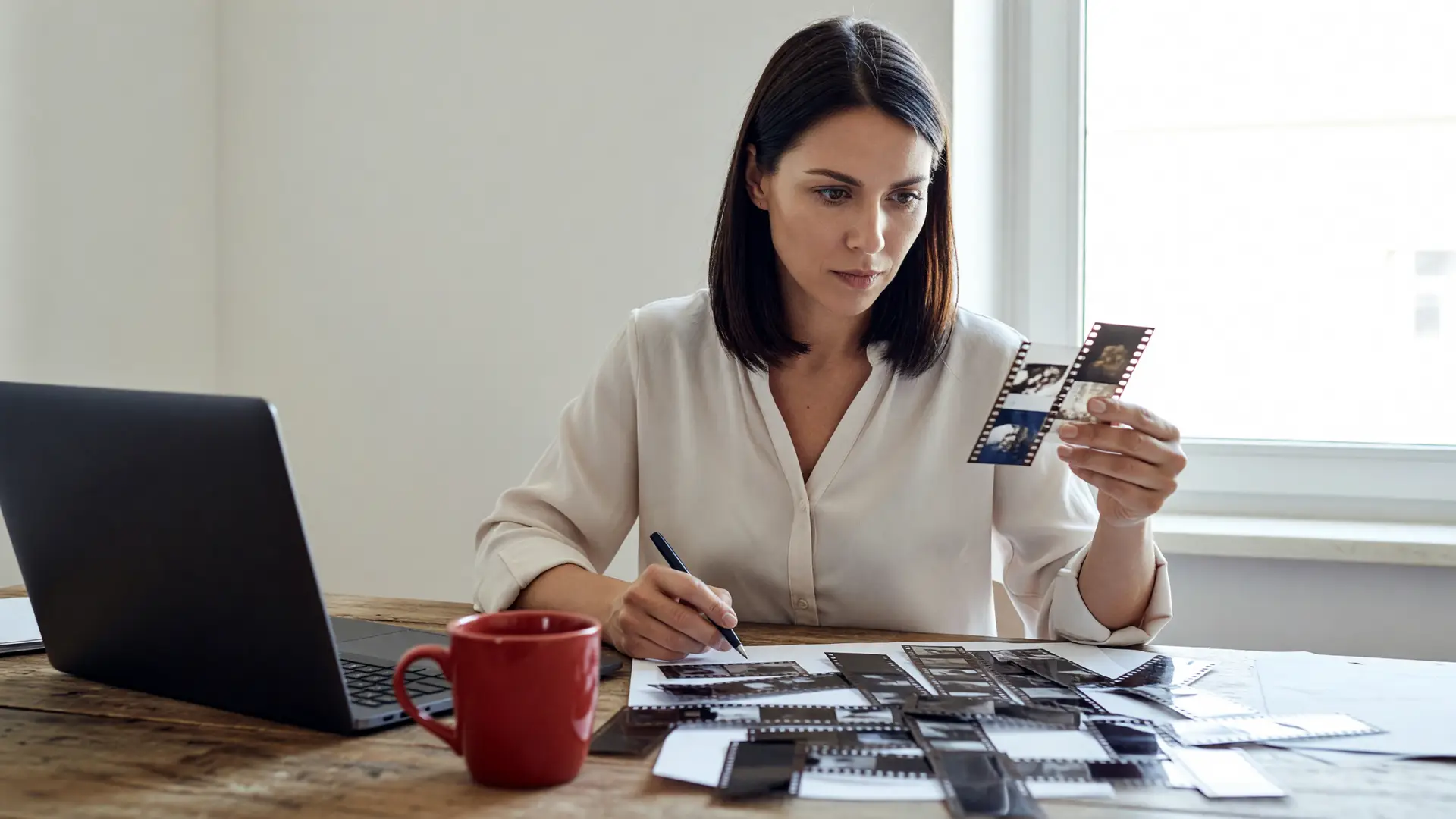 Due professionisti pianificano il budget video AI mensile su schede di lavoro in uno studio luminoso