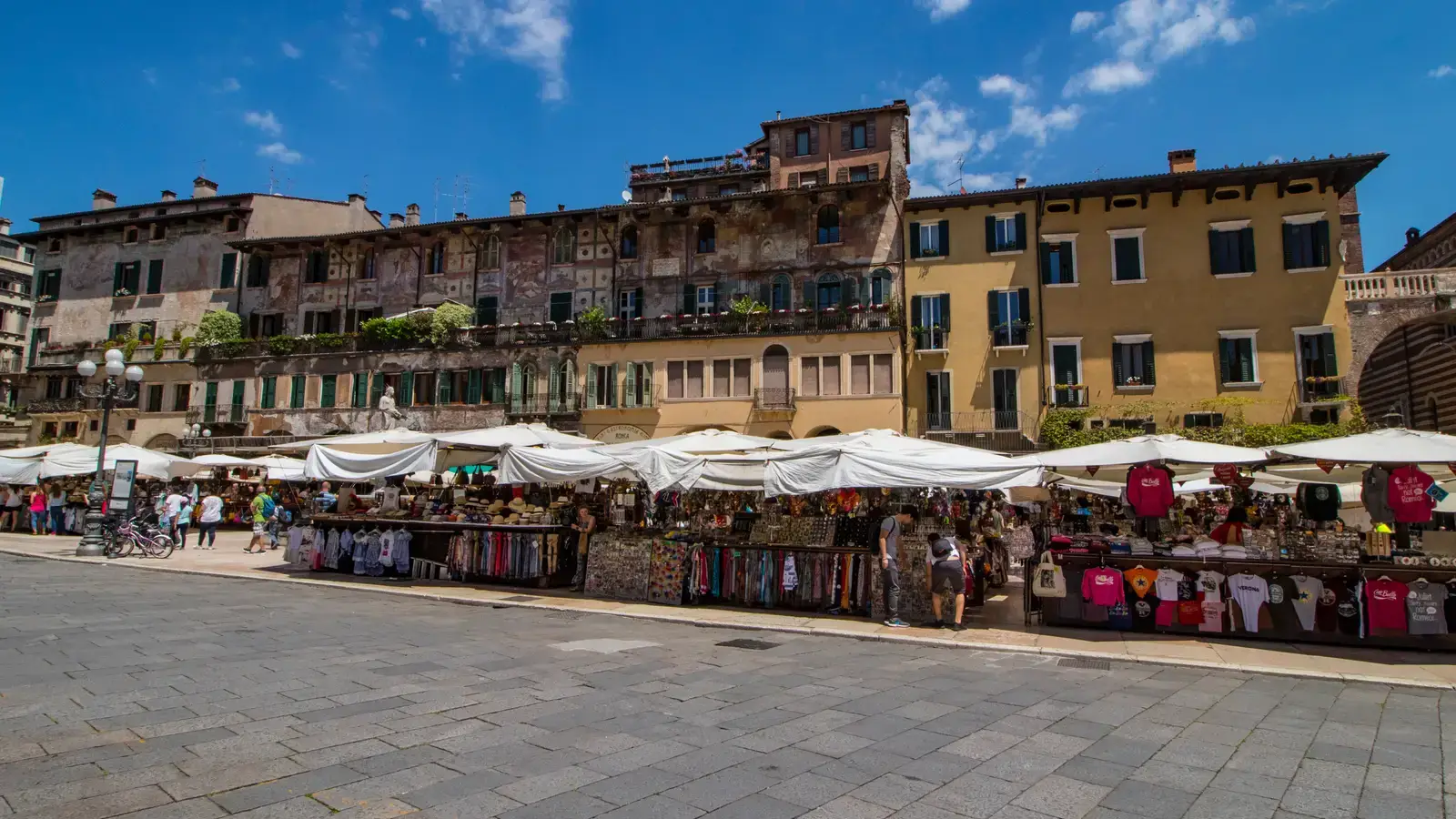 Il mercato di piazza delle Erbe a Verona, con i banchi e i palazzi affrescati